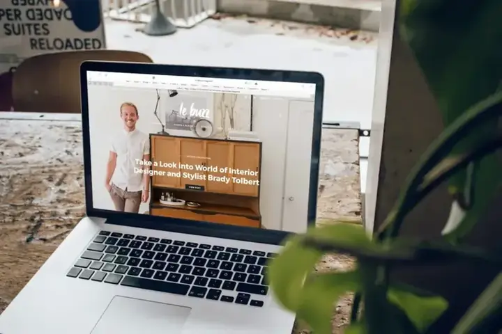 Web renderizada en un MacBook sobre una mesa de trabajo